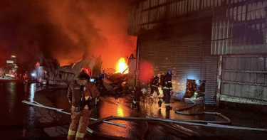 新北八里木作工廠7日凌晨發生大火，延燒3間工廠，消防人員出動60車、159人全力灌救。（圖／翻攝畫面）