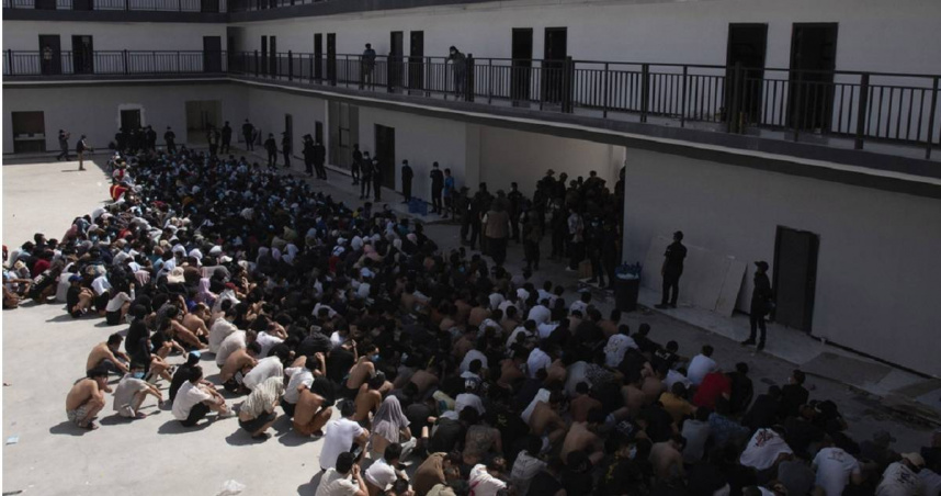 中國、越南和衣索比亞的民眾被販賣到詐騙中心工作，並在解救後戴著口罩坐在拘留所中。（圖／達志／美聯社）