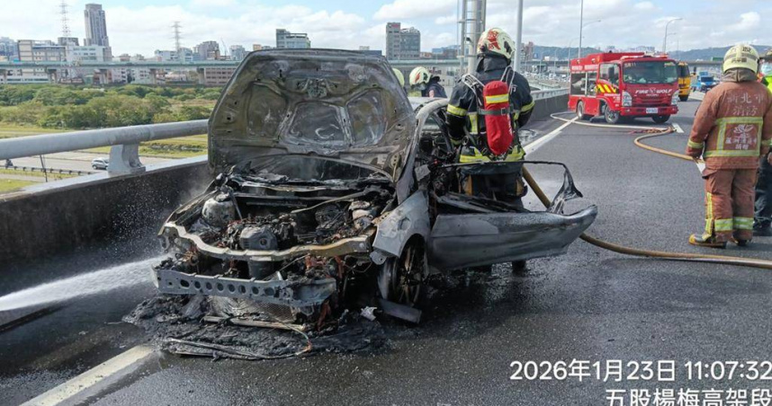 國道1號汐五高架三重路段23日上午發生火燒車事故，轎車燒成骨架，駕駛及時逃生未受傷。（圖／翻攝畫面）