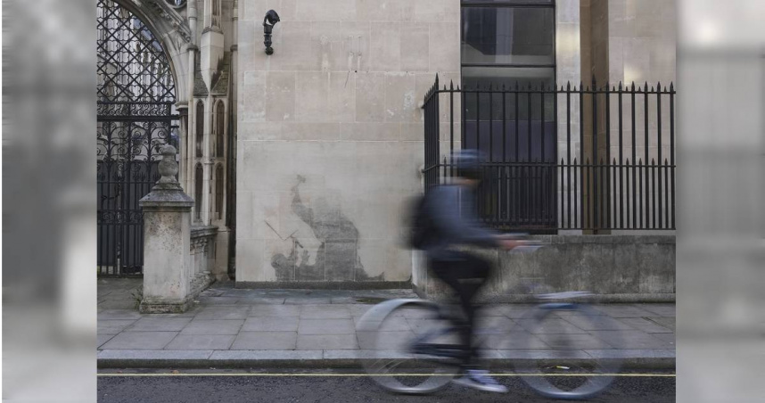 在英國倫敦的皇家司法院（Royal Courts of Justice）外牆，該作品描繪了一名法官用法槌擊打一名抗議者。在法院移除這幅作品後，人們可以看到它的殘​​骸。（圖／達志／美聯社）