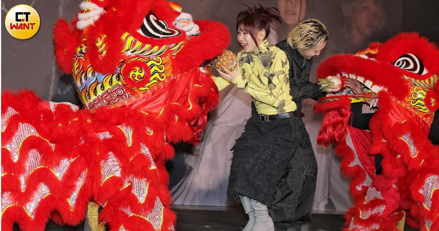 ikura（左）和Ayase從獅子口中接過象徵吉祥的鳳梨及菜頭。（圖／楊澍攝）