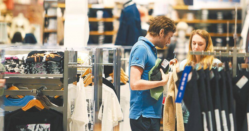 受關稅戰延期、廠商拉貨潮影響，主計總處評估下半年出口會下滑，民間消費也可能趨於保守。圖為民眾選購衣物時仔細比較。（圖／報系資料照）