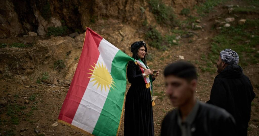 20日在伊拉克庫德斯坦自治區阿克拉鎮，一名婦女在慶祝波斯新年諾魯孜節時揮舞著庫德旗幟。 （圖／達志／美聯社）