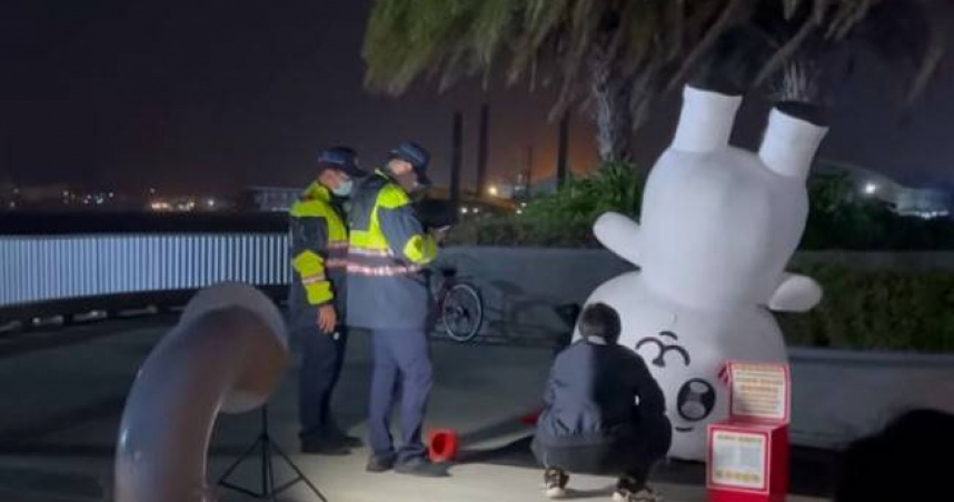 高雄港愛河灣驚見吉伊卡哇人偶倒立，且有2名員警上前關切，豈料遊客爆笑對話引發熱議。（圖／翻攝12.zonn Threads）