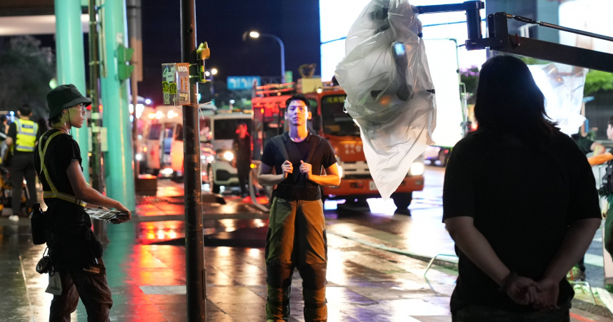 電影《96分鐘》男主角林柏宏（中）於信義區松壽路道路管制與攝影機確認拍攝位置。（圖／台北市電影委員會提供）