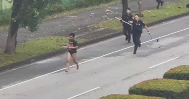 花蓮移工持刀街頭暴走，警民對峙「互丟大戰」畫面曝光。（圖／翻攝畫面）