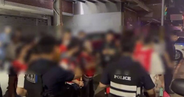 賭場負責人、工作人員及賭客全穿上藍色號碼衣,全被帶返警局訊問。(圖/翻攝畫面)