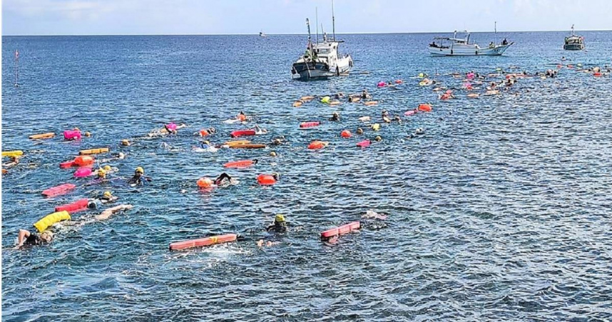 選手們頭戴五顏六色的泳帽在海中悠游，宛如海上花毯，畫面壯觀。（圖／翻攝照片）