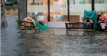 大雨狂炸高雄 騎士牽車如渡河 診所護士忙撈水