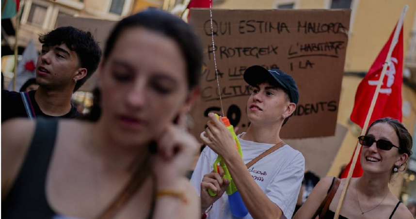 西班牙巴利阿里群島馬略卡島抗議者手持水槍，抗議過度旅遊。（圖／達志／美聯社）