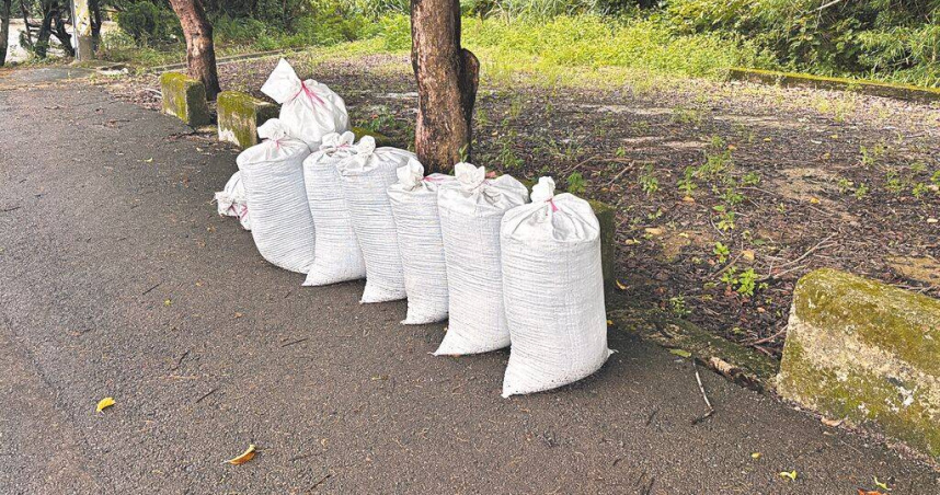 桃園市新屋區有多處農路遭不明人士棄置裝有彩色塑膠粒與細沙的太空包，疑似為分解後的廢棄電線，其中一處經民眾初步清理放置路旁，待相關單位清除，桃園市環保局已展開追查。（圖／中國時報廖姮玥攝）
