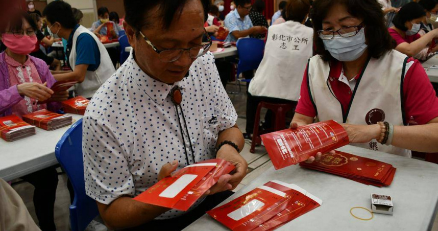 彰化市長林世賢(左)協助工作人員將禮金裝袋。（圖／中國時報葉靜美攝）