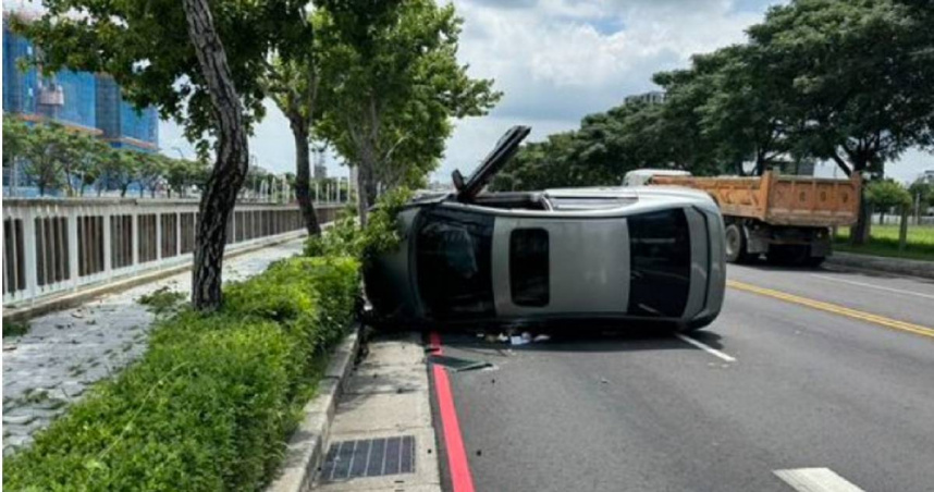 台中轎車突自撞路緣翻覆，疑因駕駛精神不濟惹禍，造成他意識模糊受困待救。（圖／翻攝畫面）