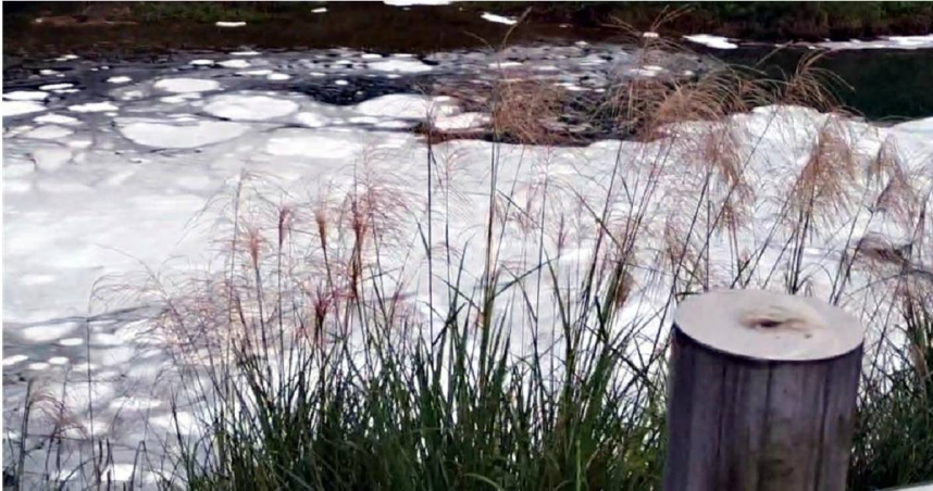 暖暖溪18日上午突然出現大量不明白色泡沫，水公司現已停止抽水，環保局則調查汙染源中。（圖／市議員連恩典提供）