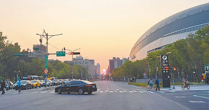 最近有民眾在台北市忠孝東路發現懸日美景，吸引不少人為留下美景不顧安危駐足行人穿越線拍照，險象環生讓旁人看了直冒冷汗。（圖／中國時報温予菱攝）