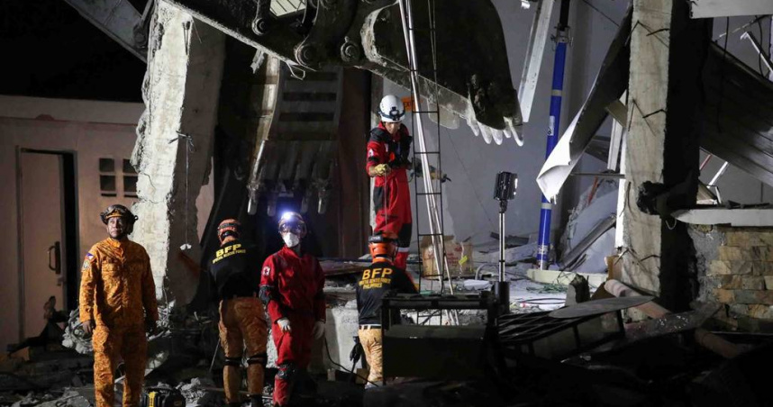 菲律賓發生規模7.8強震，多棟建築物倒塌，現場仍有許多救難人員正持續搜救生還者中。（圖／達志／美聯社）